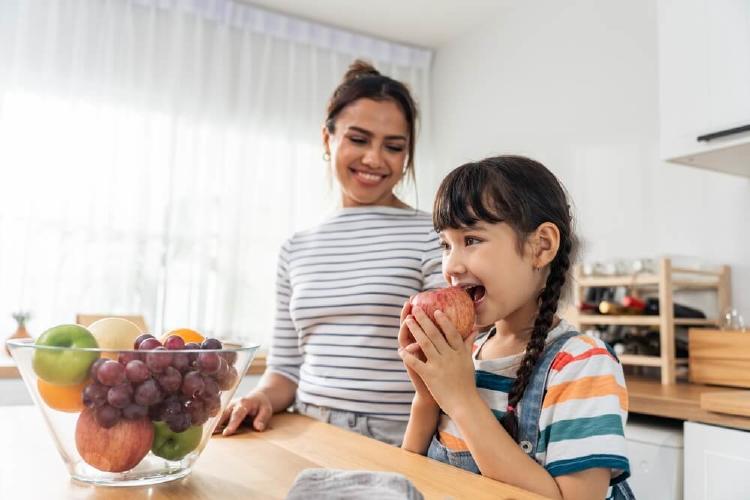 chica comiendo fruta entera