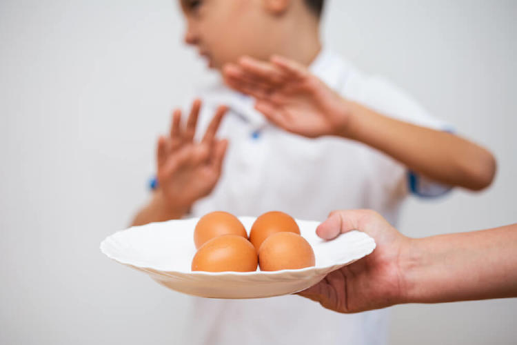 niño rechazando un plato de huevos