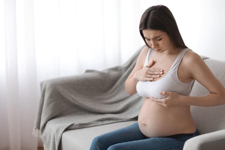 mujer embarazada palpándose el pecho
