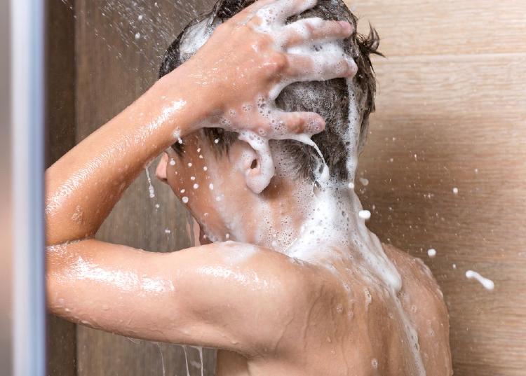 chico enjabonándose con un antifúngico en la ducha