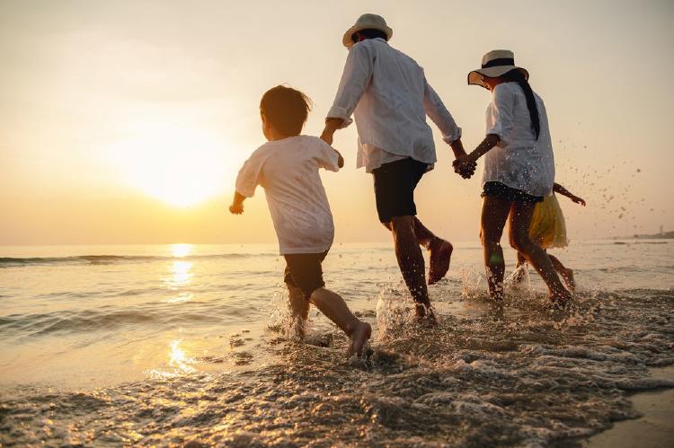 familia feliz jugando en la playa