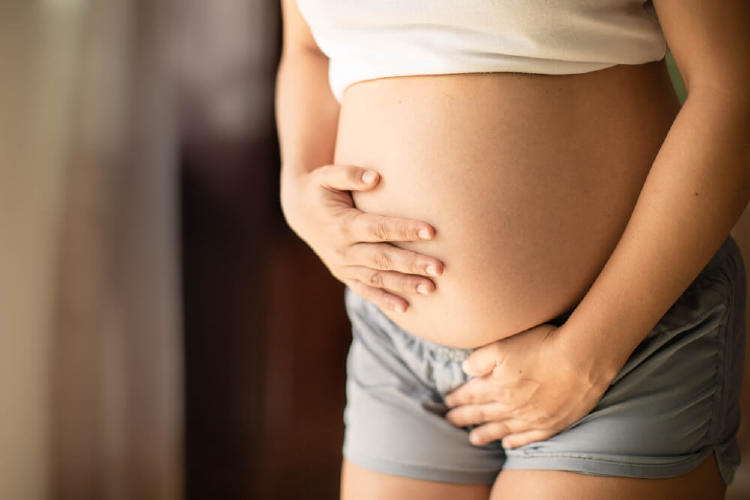 embarazada señalándose la vejiga y la barriga